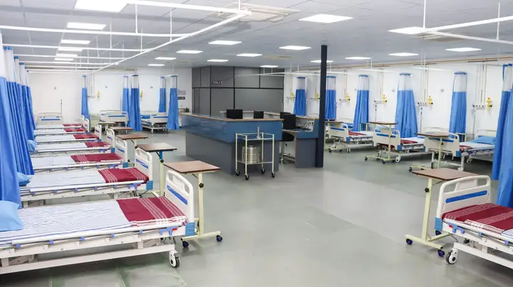 Hospital beds with curtains arranged around a central nurses' station