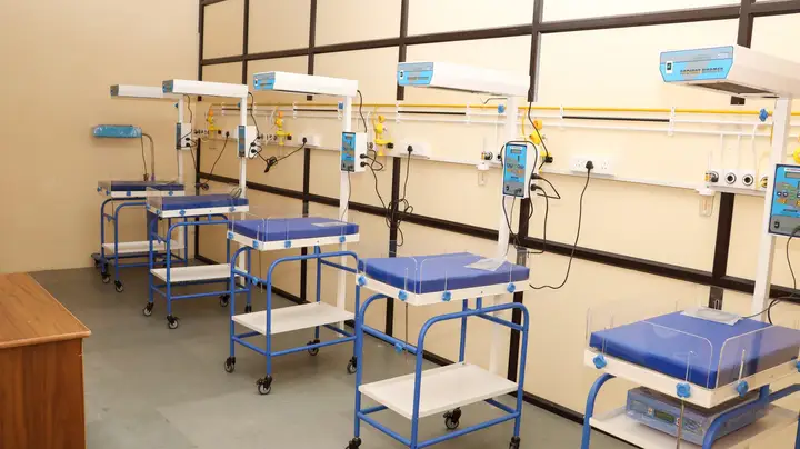 A newborn care unit with a row of baby warmers