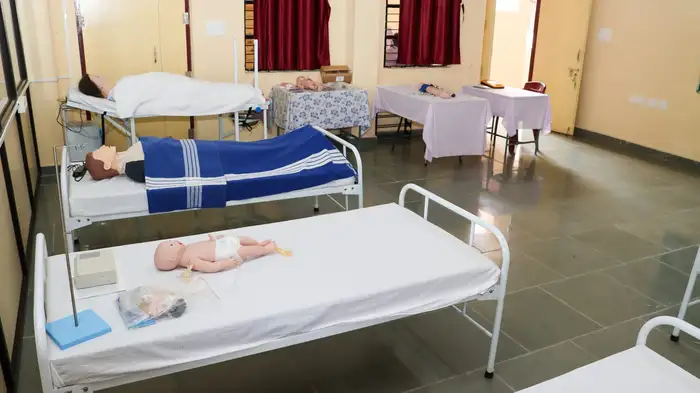 Practice manikins of an adult and a newborn baby on beds
